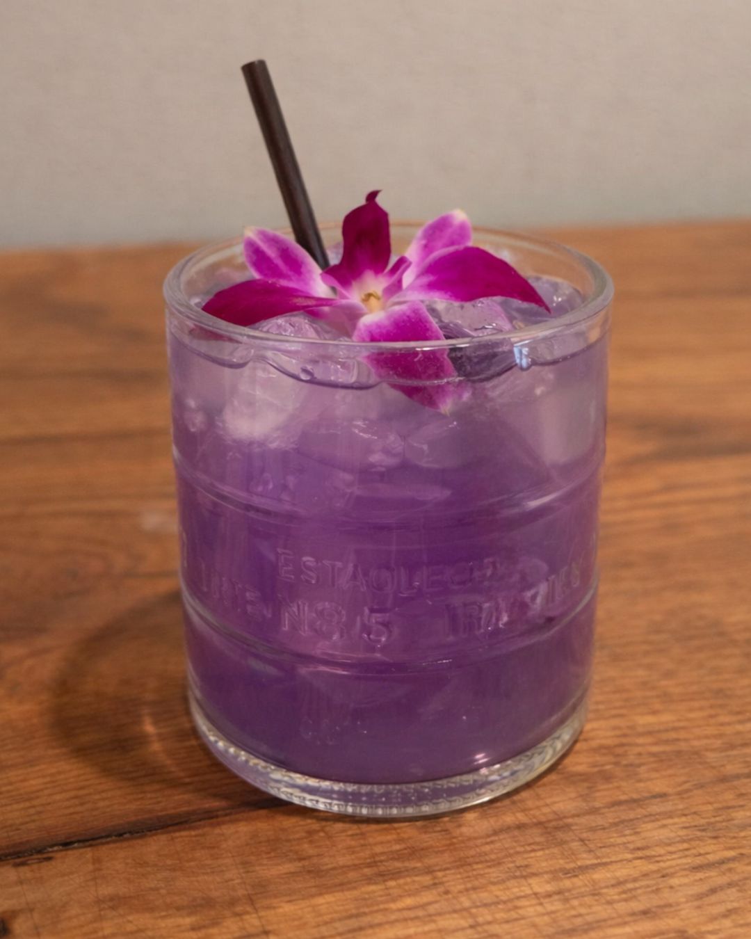 Purple Rain Sangria cocktail made with Ketel One Peach Orange Blossom, Riesling, pear, lemon, and Butterfly Pea Flower, served in an upcycled Ketel One bottle glass at LondonHouse Chicago